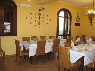 a dining room with tables and chairs with white tablecloths at Agriturismo Rajata in Bagheria