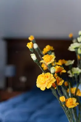 a vase filled with yellow flowers on top of a bed at Agriturismo Rajata in Bagheria