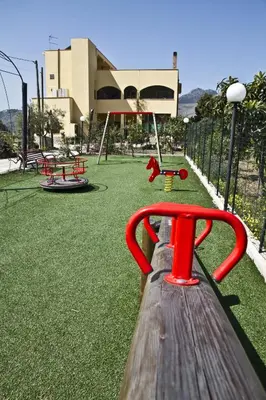 a park with a playground with red swings at Agriturismo Rajata in Bagheria
