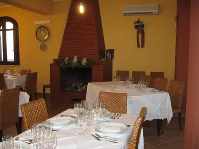 a dining room with tables and chairs and a fireplace at Agriturismo Rajata in Bagheria