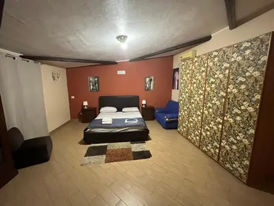 a bedroom with a bed and a blue couch at Camera relax riservata intero appartamento in Carini