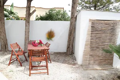 a table and chairs with flowers on a patio at Villa Maria in San Vito lo Capo