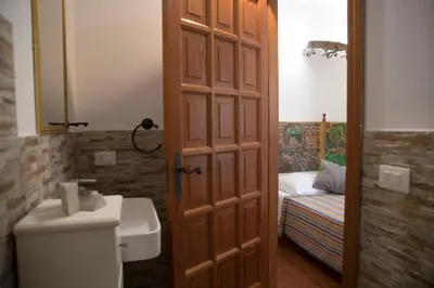 a bathroom with a toilet and a sink and a door at Villa I Due Pini in San Vito lo Capo