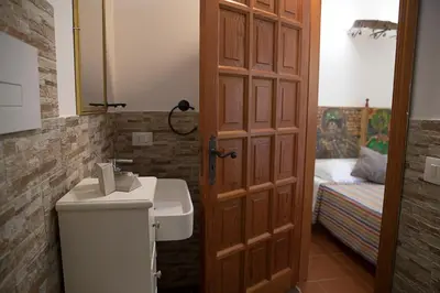 a bathroom with a sink and a toilet and a mirror at Villa I Due Pini in San Vito lo Capo