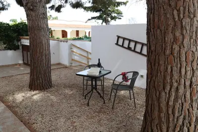 a table and two chairs sitting next to a tree at Villa I Due Pini in San Vito lo Capo