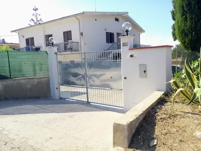 a gate in front of a white house at Casa Vacanza Mare in Castellammare del Golfo