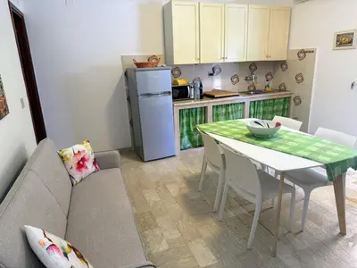 a kitchen and dining room with a table and a couch at Casa Vacanza Mare in Castellammare del Golfo