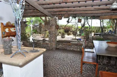 a kitchen with a counter and a table and a table and chair at Villa Il Cappero in San Vito lo Capo