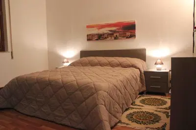 a bedroom with a bed and a night stand with two lamps at La Casetta in Palermo