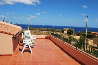 a balcony with two chairs and a view of the ocean at Casa Vacanze La Terrazza Sul Golfo in Castellammare del Golfo