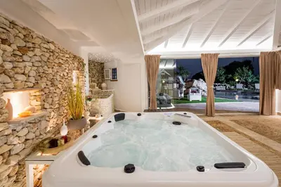 a large bath tub in a room with a stone wall at Villa esclusiva Milazzo Annarita in Castellammare del Golfo