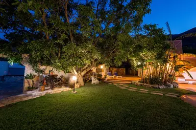 a backyard with a tree and a table and chairs at Villa esclusiva Milazzo Annarita in Castellammare del Golfo