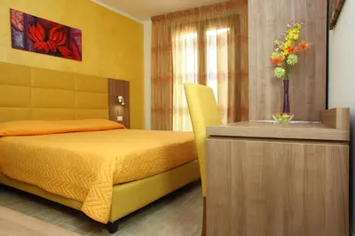 a bedroom with a yellow bed and a dresser at Coralia Bed & Breakfast in San Vito lo Capo