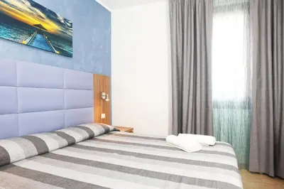 a bedroom with a bed with a blue wall at Coralia Bed & Breakfast in San Vito lo Capo