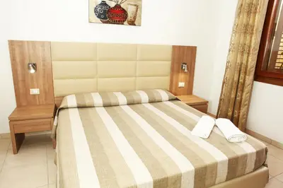 a bedroom with a bed with two white towels on it at Coralia Bed & Breakfast in San Vito lo Capo