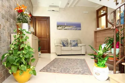 a living room with a couch and some plants at Coralia Bed & Breakfast in San Vito lo Capo