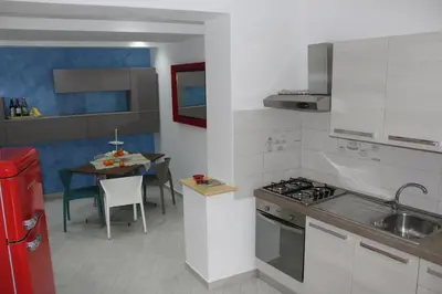 a kitchen with a sink and a stove and a table at B&B Xenia in Palermo