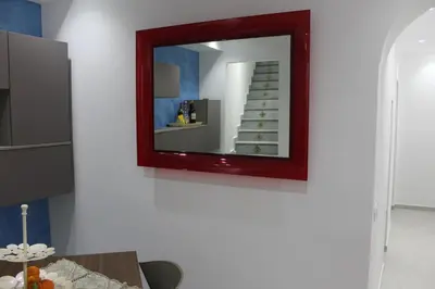 a mirror hanging on a white wall with a table at B&B Xenia in Palermo