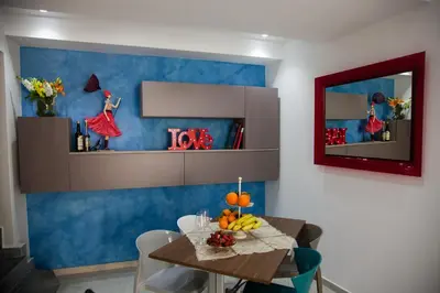 a dining room with a table and a blue wall at B&B Xenia in Palermo