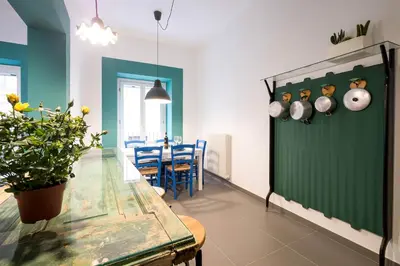 a dining room with a table and a green wall at Cassari UpArtments in Palermo