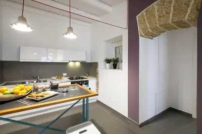 a kitchen with a table with a bowl of fruit on it at Cassari UpArtments in Palermo