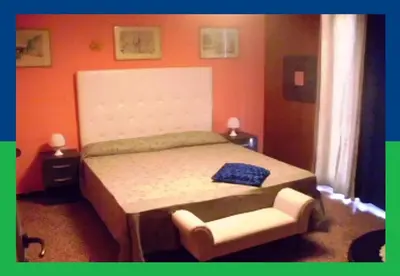 a bedroom with a bed and a chair at Santa Oliva Homestay in Palermo