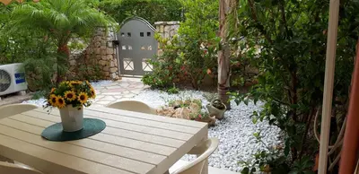 a table with a vase of flowers on top of a garden at Villa Iris in Castellammare del Golfo