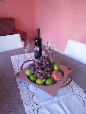 a plate of fruit and a bottle of wine on a table at Villa Iris in Castellammare del Golfo