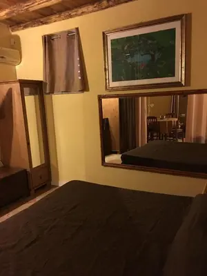 a room with a mirror and a bed and a table at Junior Suite Cattedrale in Palermo