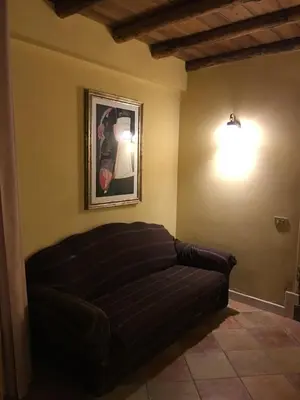 a black couch in a room with a picture on the wall at Junior Suite Cattedrale in Palermo