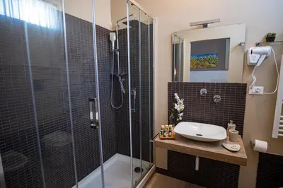 a bathroom with a glass shower and a sink at Le Muse Mondello in Mondello