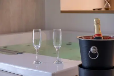 two wine glasses and a bucket with a bottle of champagne at Le Muse Mondello in Mondello