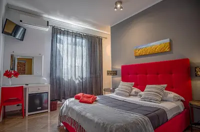 a bedroom with a large bed with a red headboard at Le Muse Mondello in Mondello
