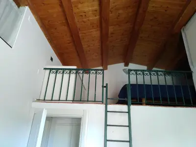 a staircase in a room with a wooden ceiling at Olivella Suite Ecological House in Palermo