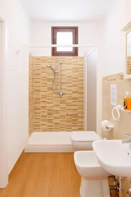a bathroom with two toilets and a shower at Il Glicine Appartamenti & Rooms in Castellammare del Golfo