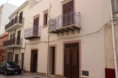 a black car parked in front of a building at Il Glicine Appartamenti & Rooms in Castellammare del Golfo