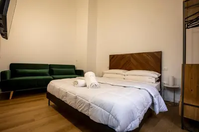 a bedroom with a bed and a green couch at Vespri Apartments in Palermo