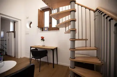 a staircase in a room with a table and a chair at Vespri Apartments in Palermo