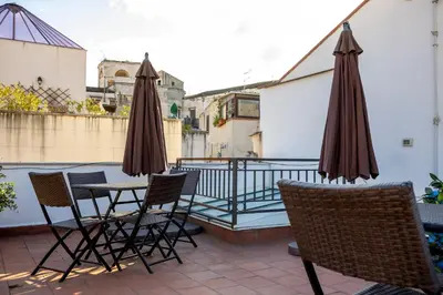 a patio with chairs and tables and umbrellas at Vespri Apartments in Palermo
