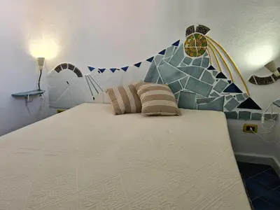a bedroom with a large bed with a mosaic wall at casa sul mare in Terrasini