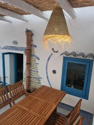 a dining room with a wooden table and a chandelier at casa sul mare in Terrasini
