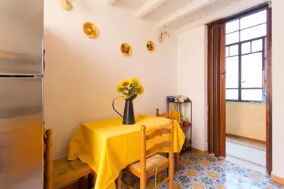 a yellow table with a vase of flowers on it at Casa nobiliare in Palermo