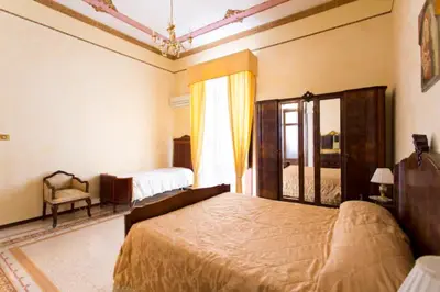a bedroom with a large bed and a window at Casa nobiliare in Palermo