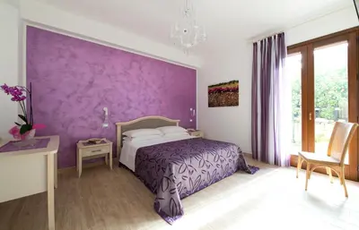 a purple bedroom with a bed and a purple wall at I Segreti di Antonina in Castelluzzo