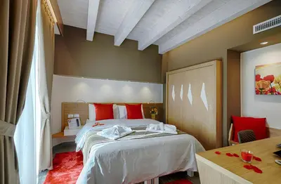 a bedroom with a large bed with red pillows at Hospitality Hotel in Palermo