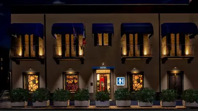 a building with blue awnings and plants in front of it at Hospitality Hotel in Palermo