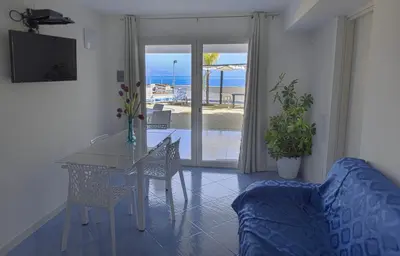 a living room with a table and a couch at Villa Trinacria Apartments in Alcamo Marina