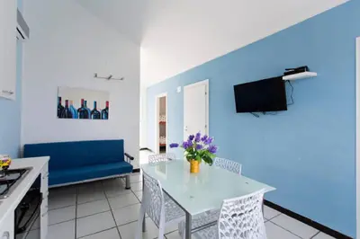 a living room with a table and a blue wall at Villa Trinacria Apartments in Alcamo Marina