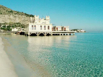 a large white building on a pier over the water at Casakameusa in Palermo