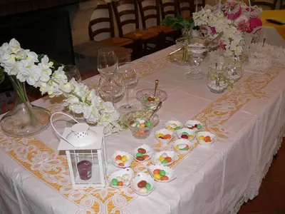 a table with a white table cloth with dishes and flowers at Il Noce Antico in Bisacquino